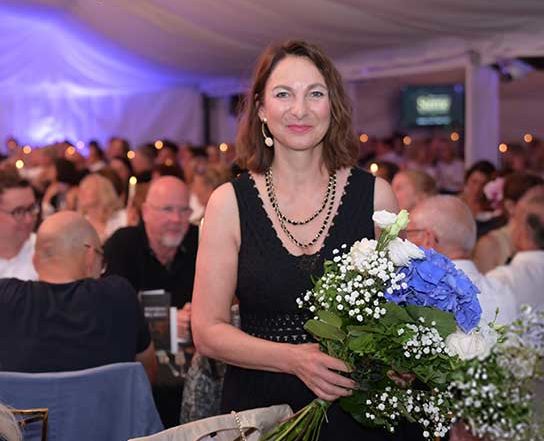 Caroline Kratzsch von Körpernah nach der Eröffnungsrede mit einem Blumenstrauß in der Hand.